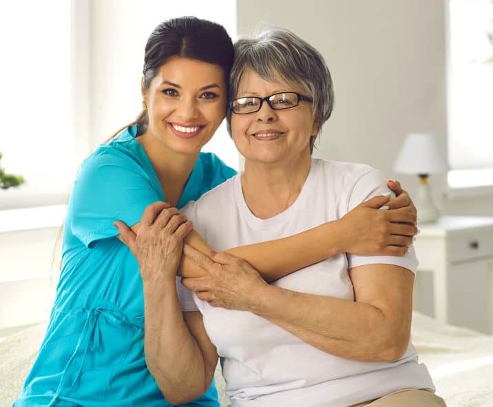 Health care woman hugging old woman