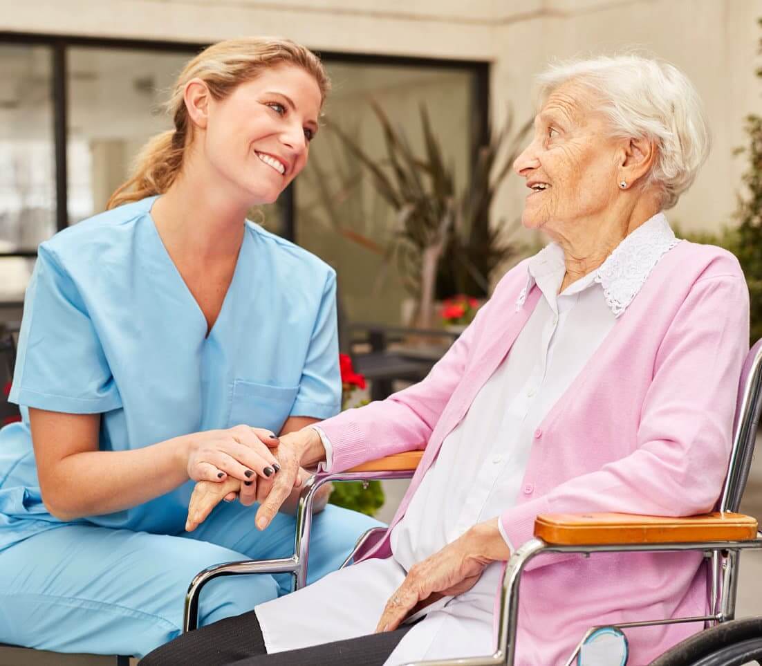 Health care woman looking at a smiling old woman