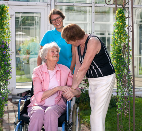 two senior woman together with their caregiver
